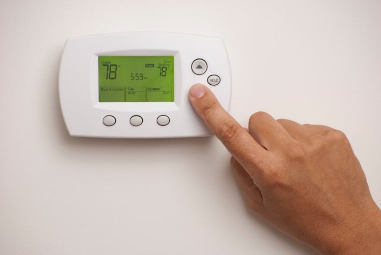 finger pressing white thermostat button min